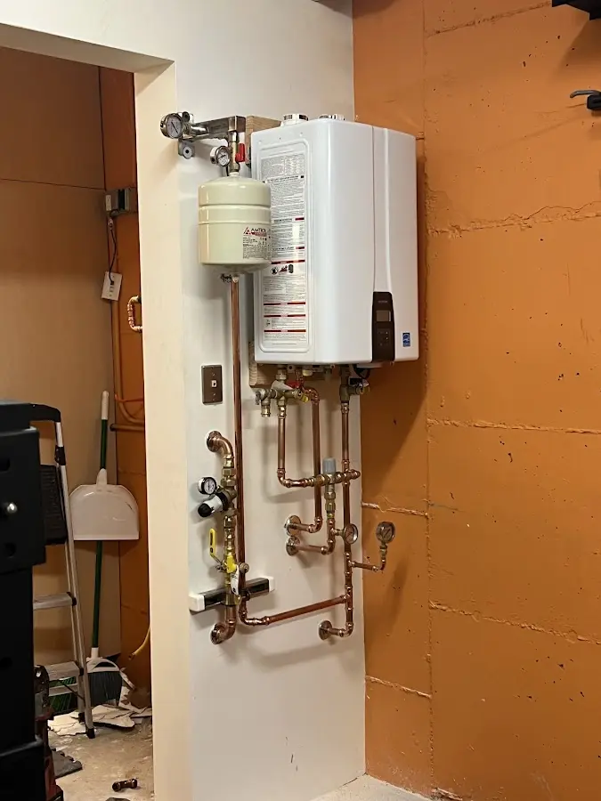 Plumbing technician inspecting water heater connections in Cranberry